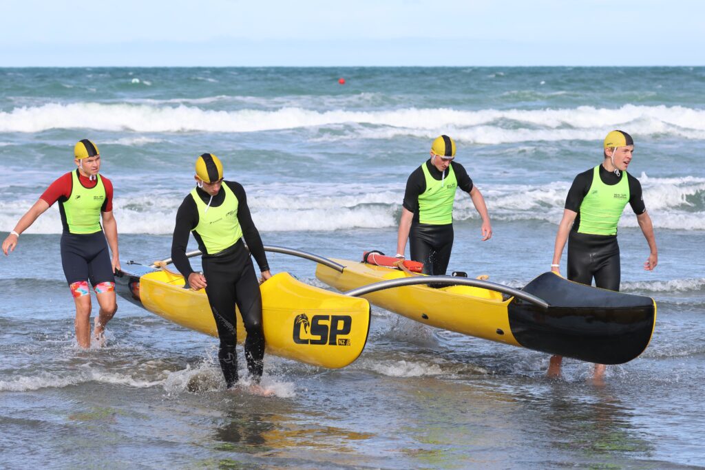 The WildCat Twin Hull Surf Canoe being carried out of the surf