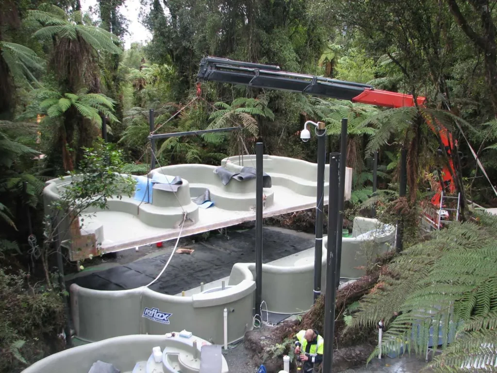 A crane lowering the hot pool mould in place